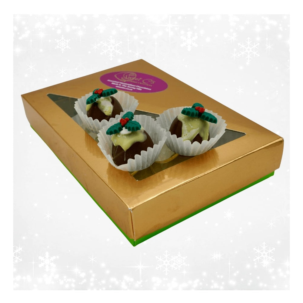 Gold box containing twelve chocolate Christmas puddings with green and red decorations on a white background