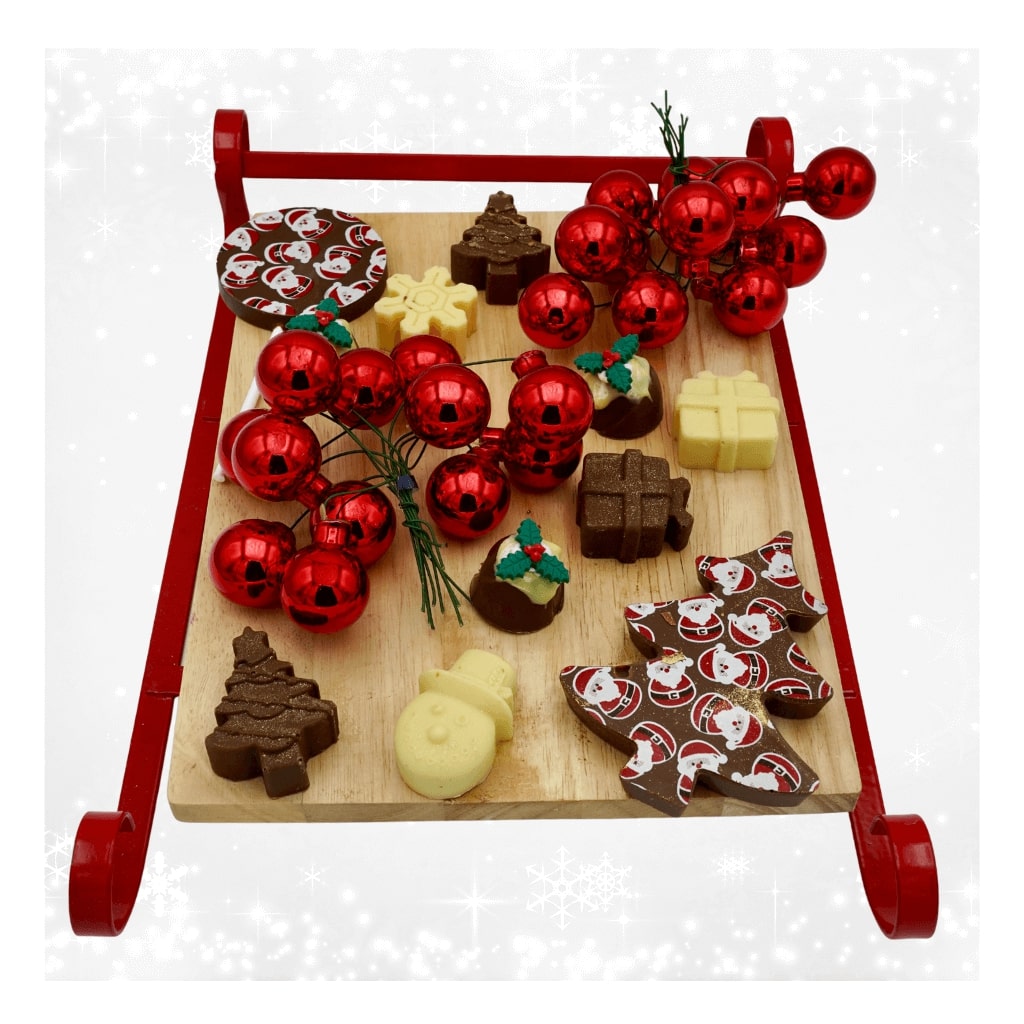 
                  
                    Wooden tray with Christmas-themed treats and decorations on a white background
                  
                