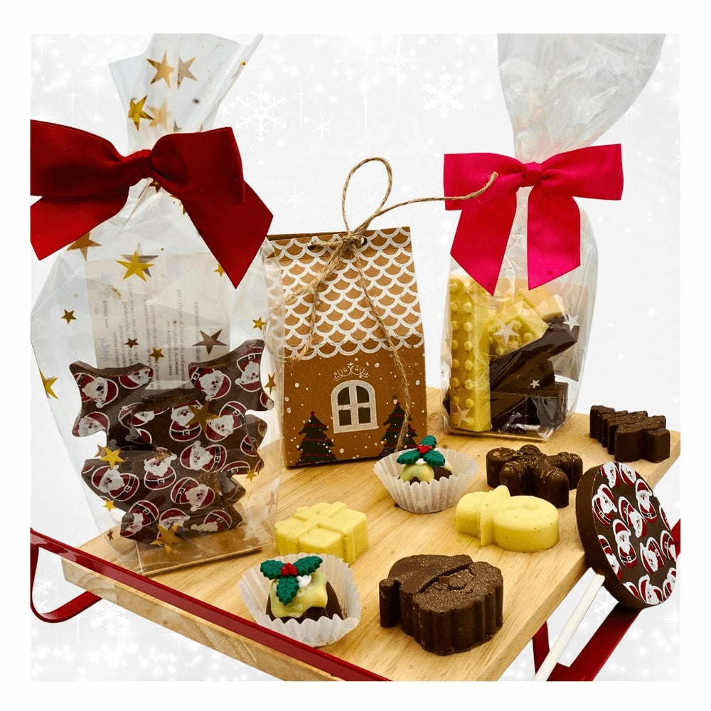 
                  
                    Assorted chocolates in decorative packaging on a wooden board with gift bags.
                  
                