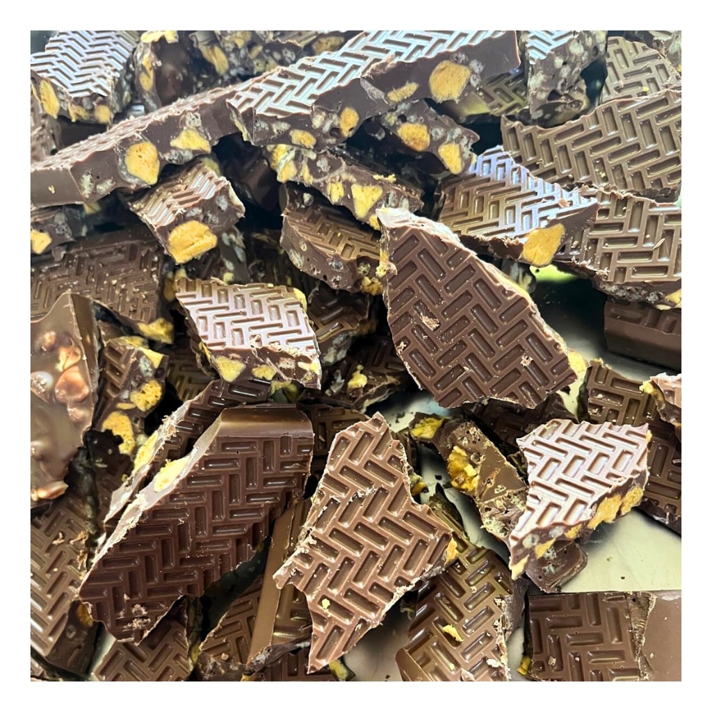 
                  
                    Pile of milk chocolate honeycomb krisp pieces with geometric pattern
                  
                