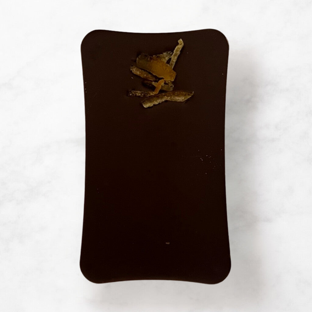 
                  
                    Dark chocolate bar with dried orange on a white background
                  
                