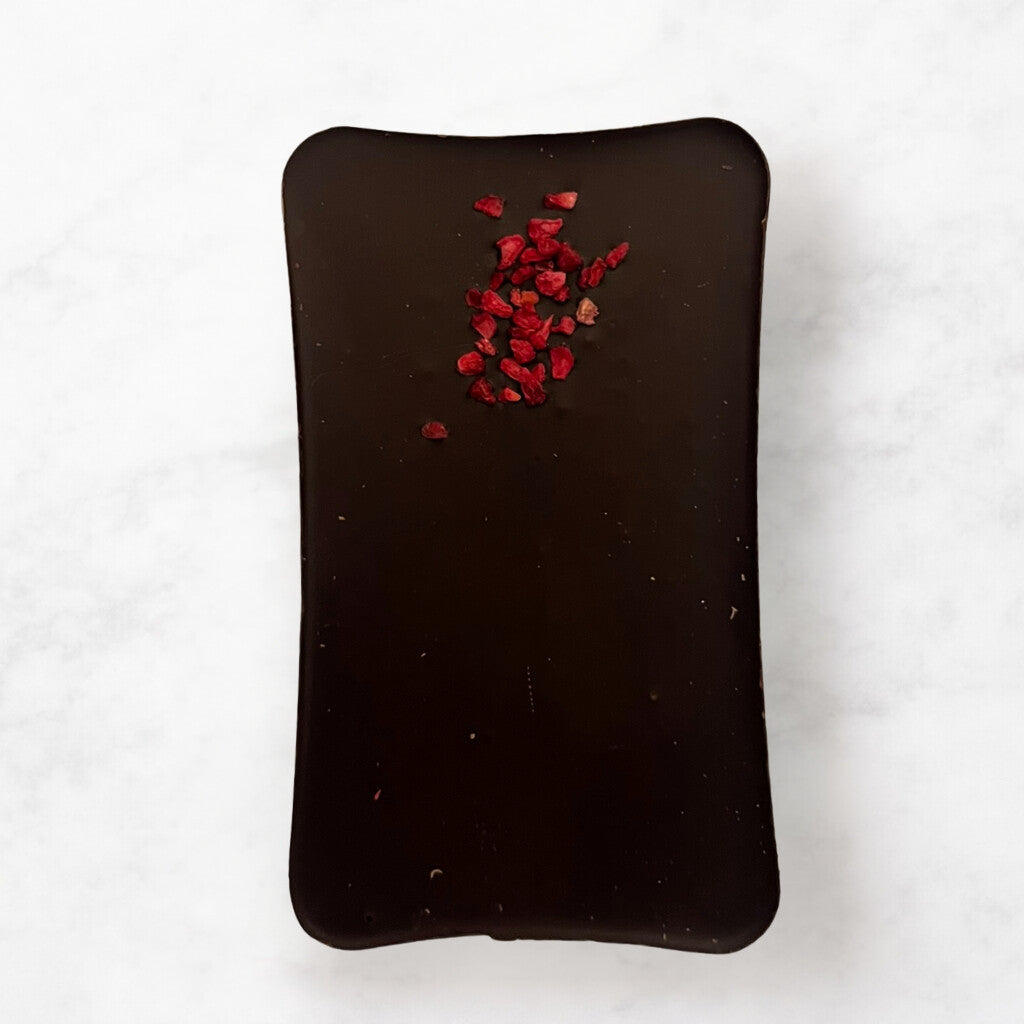 
                  
                    Dark chocolate bar with freeze-dried raspberry pieces on a white background
                  
                